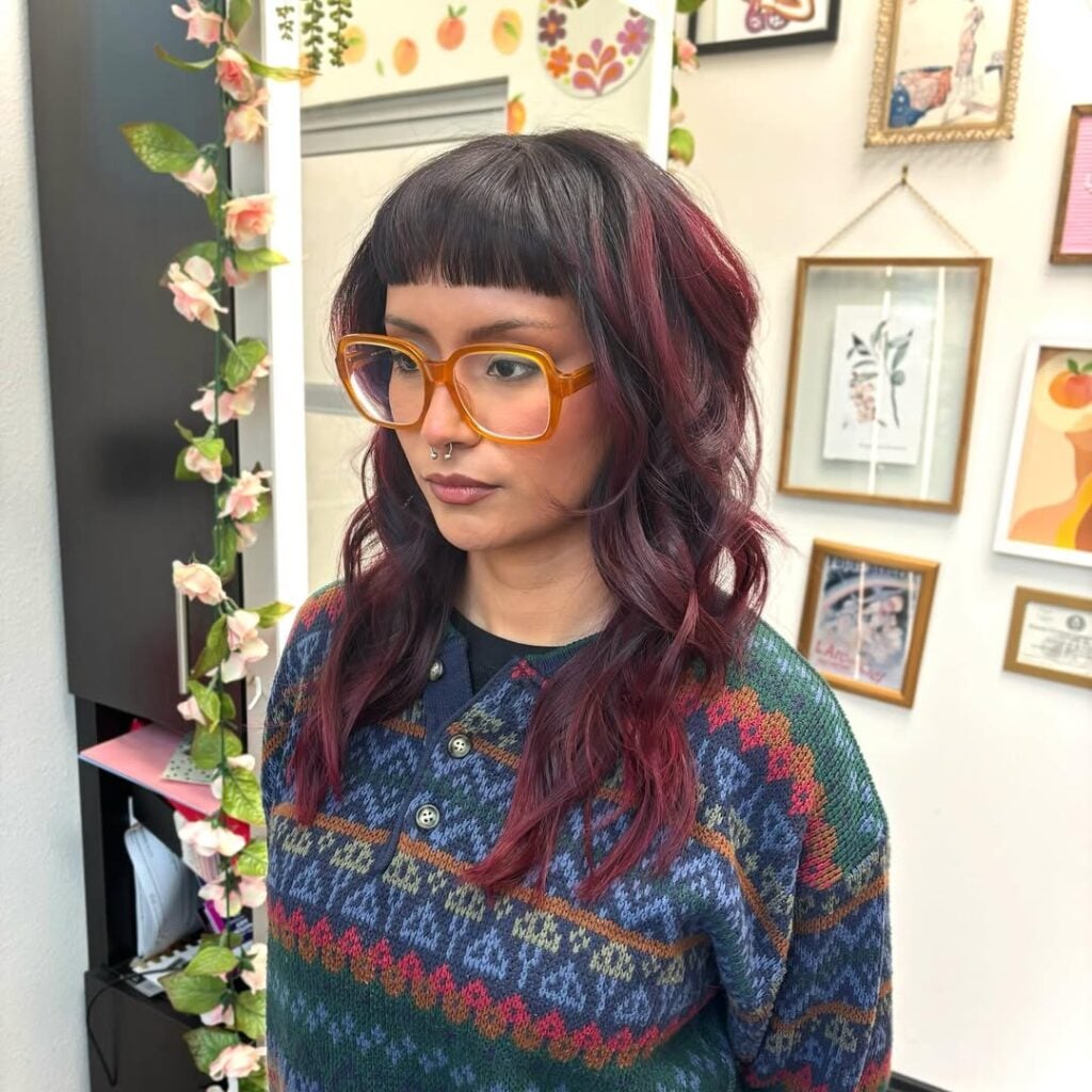 Mulher de pele clra, com cabelo colorido com franja baby