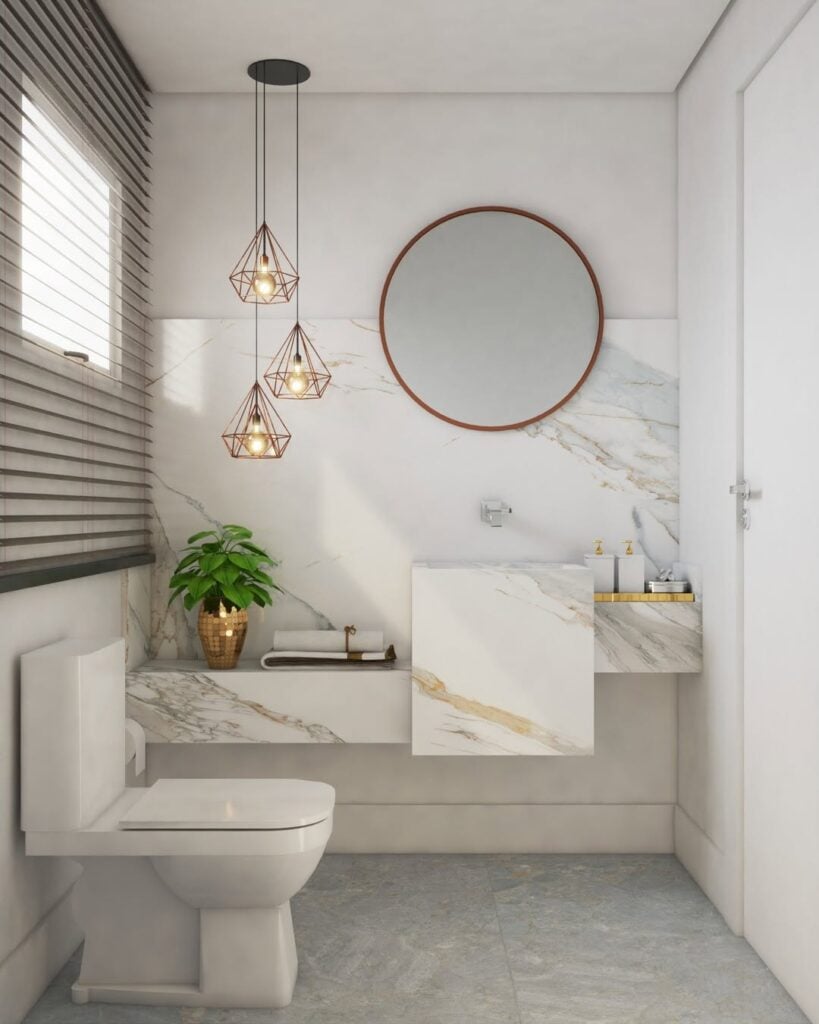 Lavabo branco com espelho redondo, pendentes e bancada marmorizada