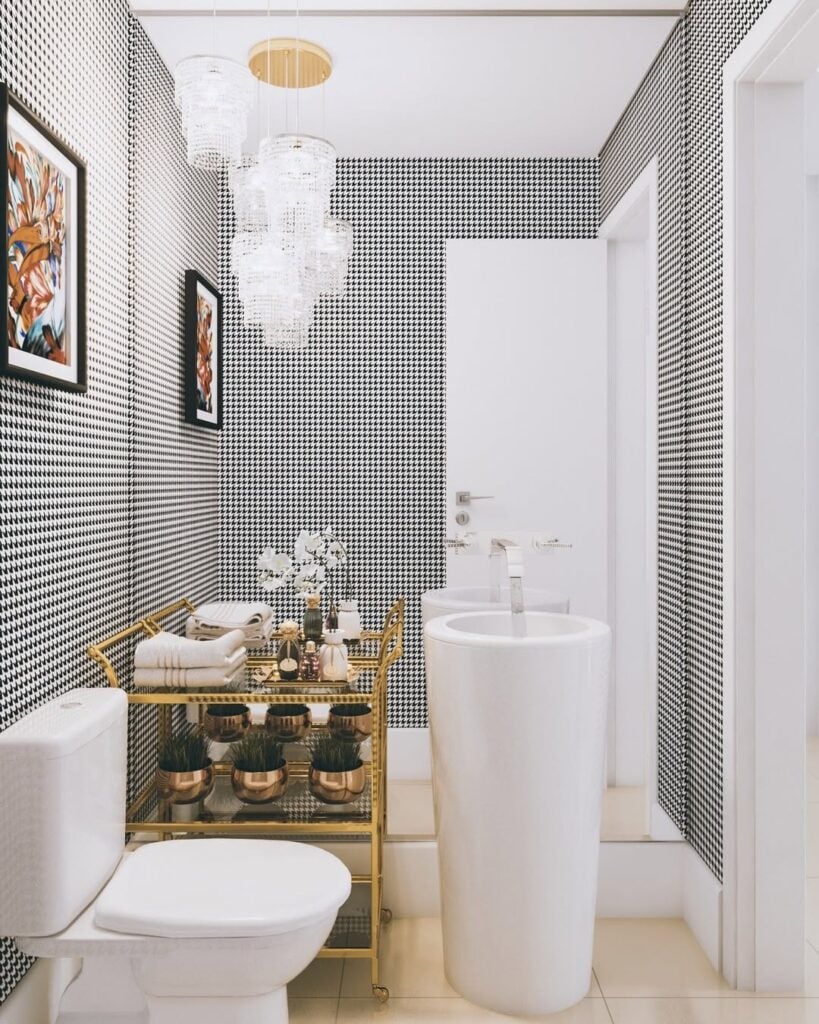 Lavabo pequeno com papel de parede branco e preto, carrinho dourado e cuba branca