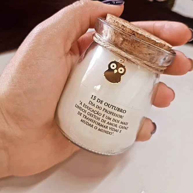 Mão segurando um vidro com vela aromática