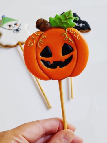 Biscoito no palito com desenho de abóbora