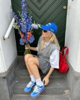 @linda.sza usando look cinza, boné azul e Adidas SL 72 azul