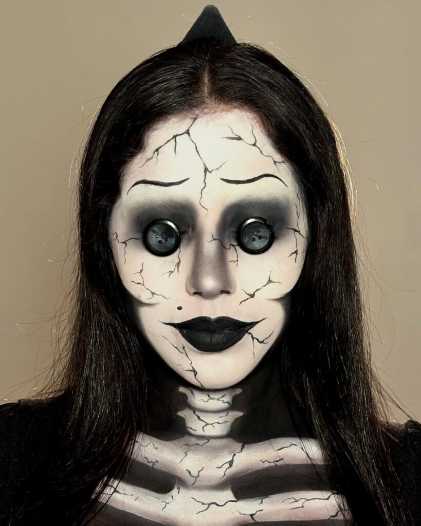 Mulher de cabelo escuro com maquiagem inspirada no filme Coraline