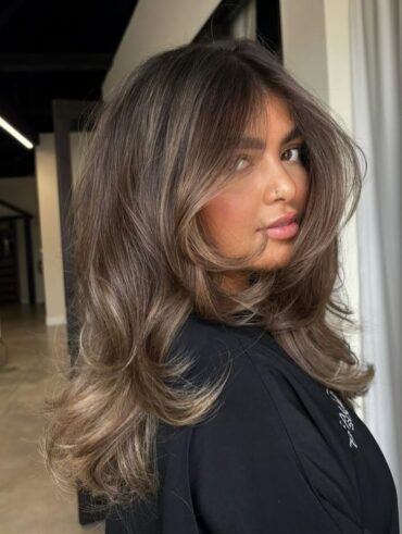 Mulher de pele clara, com cabelo liso escuro com mechas