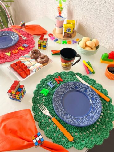 Mesa posta de dia das crianças com sousplats de crochê rosa e verde
