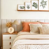 Cama com cabeceira estofada e mesa de cabeceira de madeira com gavetas brancas