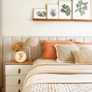 Cama com cabeceira estofada e mesa de cabeceira de madeira com gavetas brancas