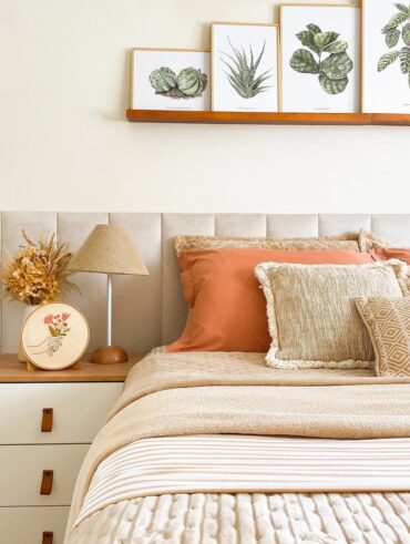 Cama com cabeceira estofada e mesa de cabeceira de madeira com gavetas brancas