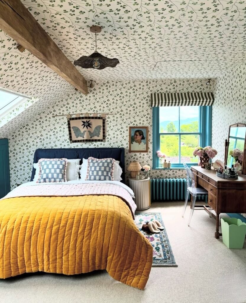 Quarto com janela azul, escrivaninha de madeira e papel de parede floral delicado