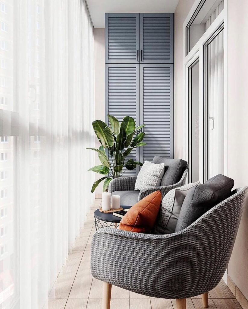 Varanda de apartamento com poltronas, almofadas e vaso de planta