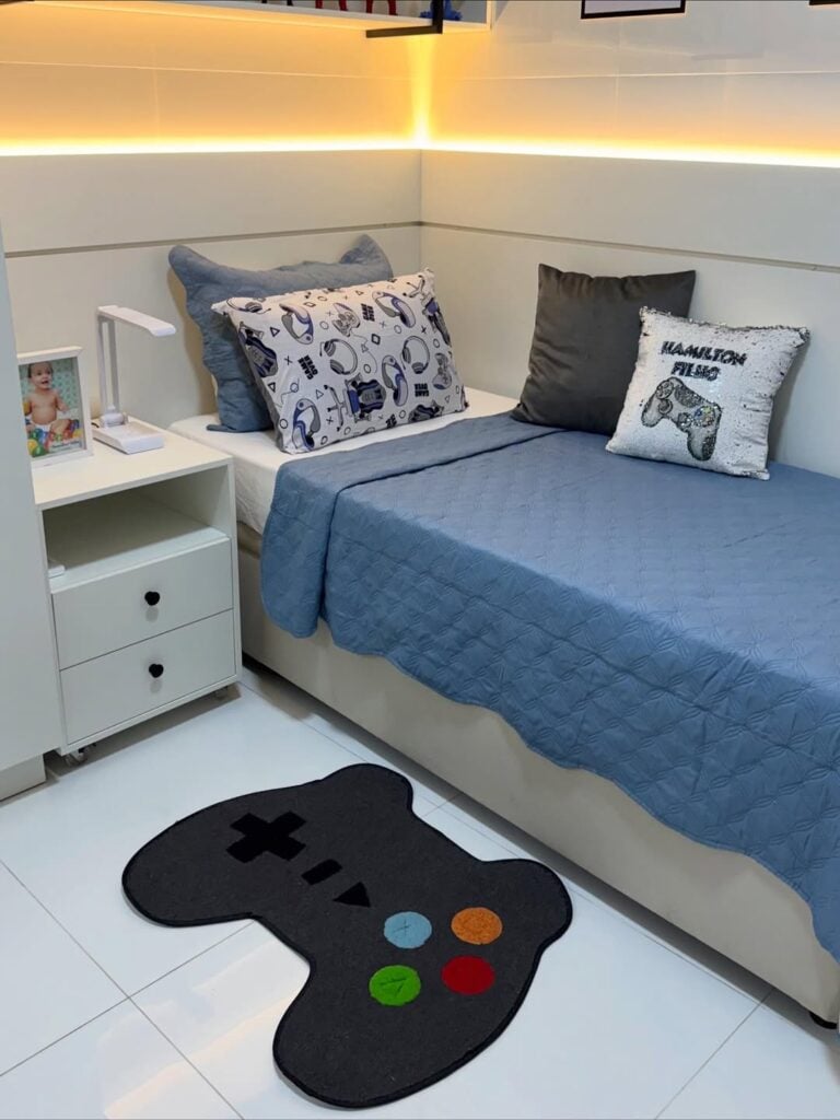 Quarto de menino com tapete e almofadas temáticos de vídeo-game e roupas de cama em tons de azul