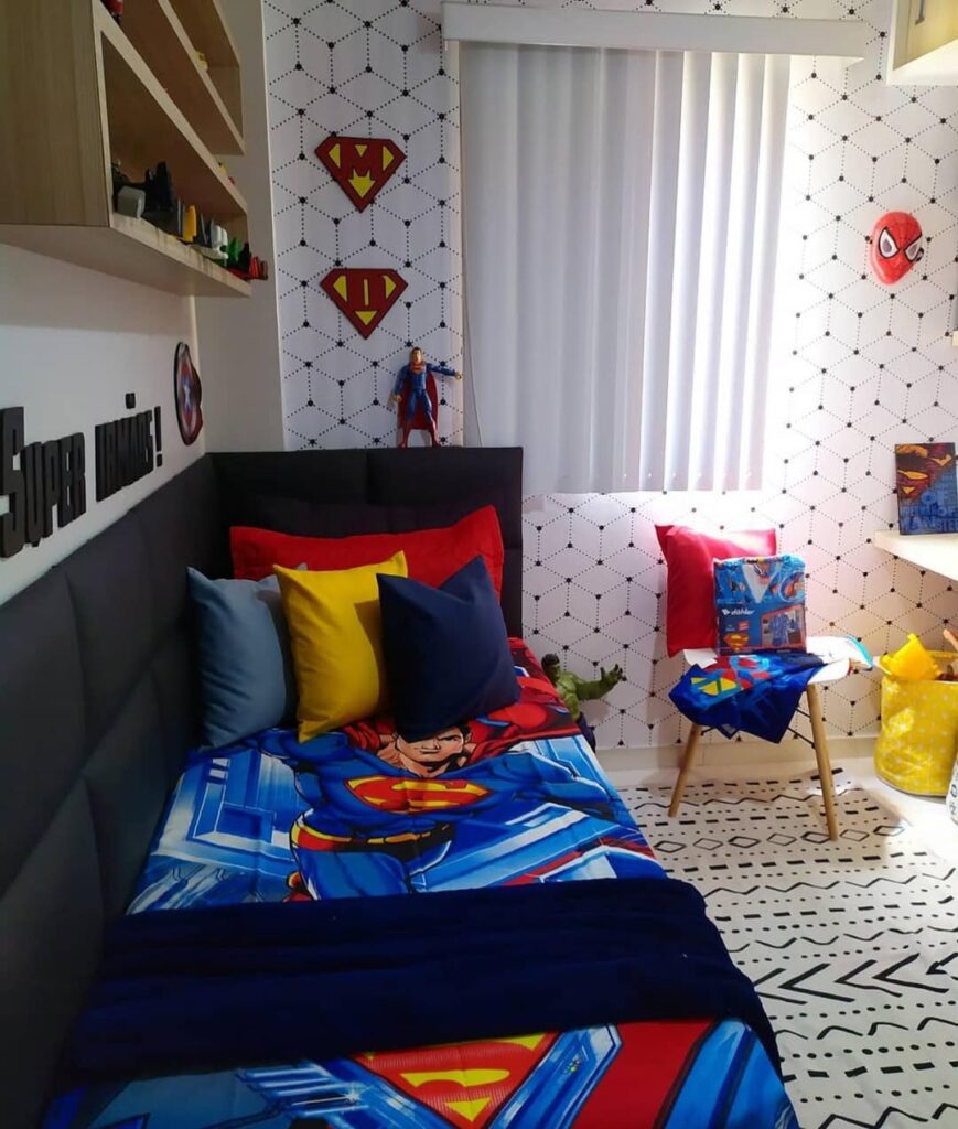 Quarto com temática de super-heróis, almofadas coloridas na cama e enfeites na parede