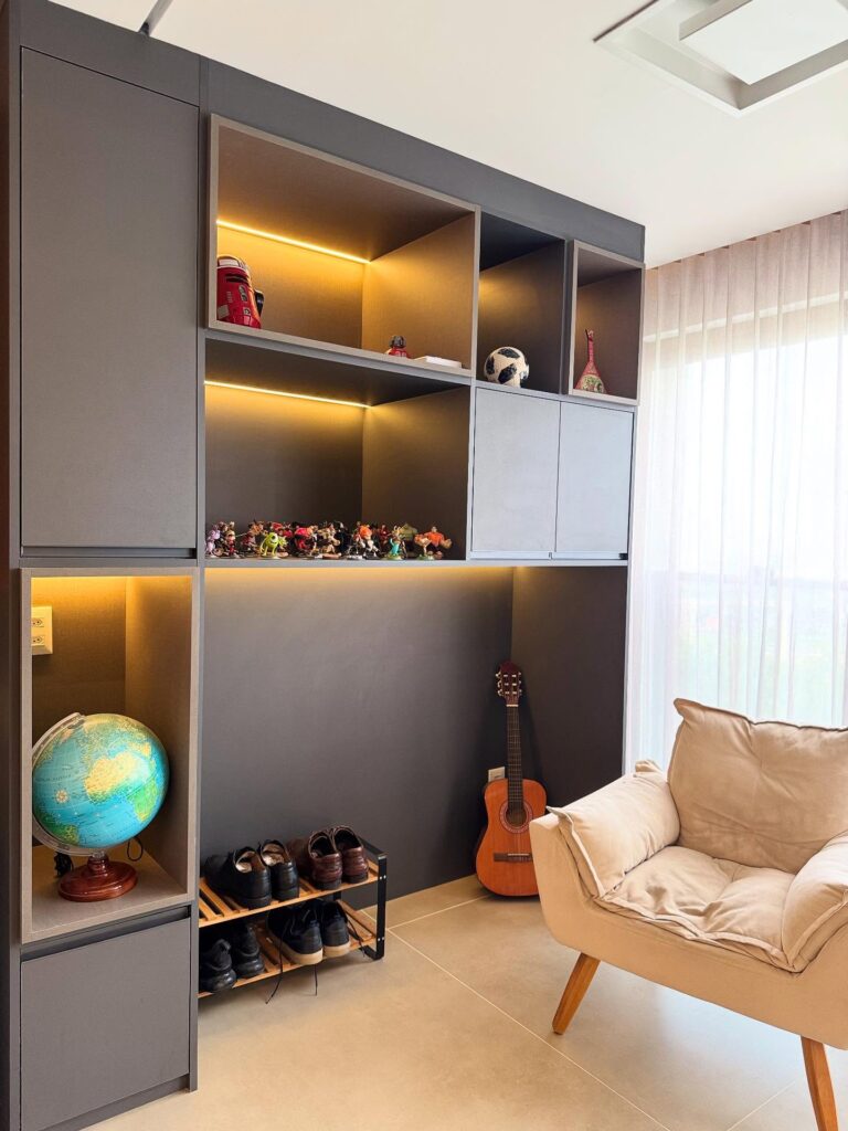 Quarto de adolescente menino em tons neutros estante e poltrona