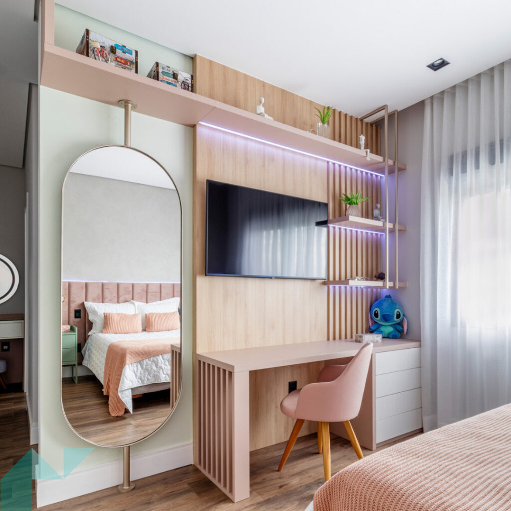 Quarto de adolescente menina em tons neutros e rosa, com mesa de estudos, espelho e TV