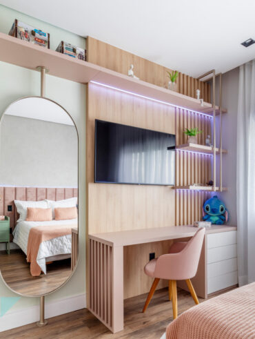 Quarto de adolescente menina em tons neutros e rosa, com mesa de estudos, espelho e TV