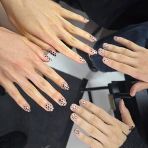 Mão de pele branca com nail art poá