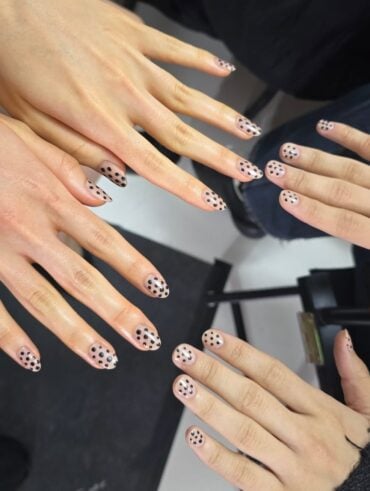 Mão de pele branca com nail art poá