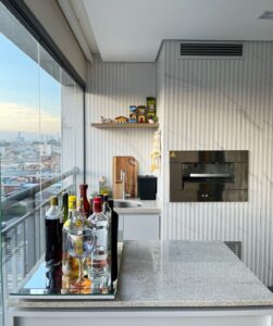 Varanda gourmet com balcão de bar e churrasqueira