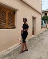 Mulher jovem e magra usando look todo preto e salto Anabela preto