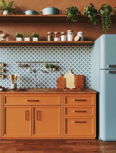 Cozinha com armário alaranjado, geladeira azul e azulejos azuis e branco