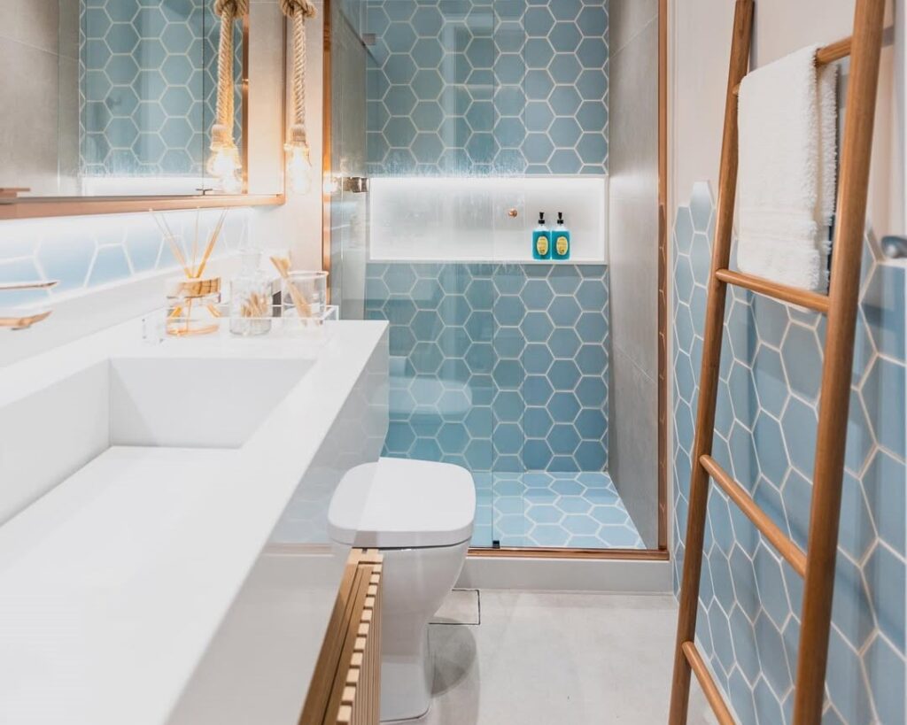 Banheiro com estética de praia em azul, branco e detalhes em madeira