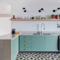Cozinha na cor verde-água, prateleira de madeira com temperos e luzes direcionáveis