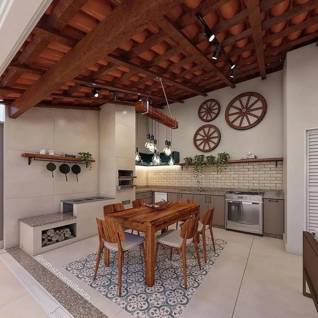 Ambiente com churrasqueria, mesa de madeira e lãmpadas penduradas