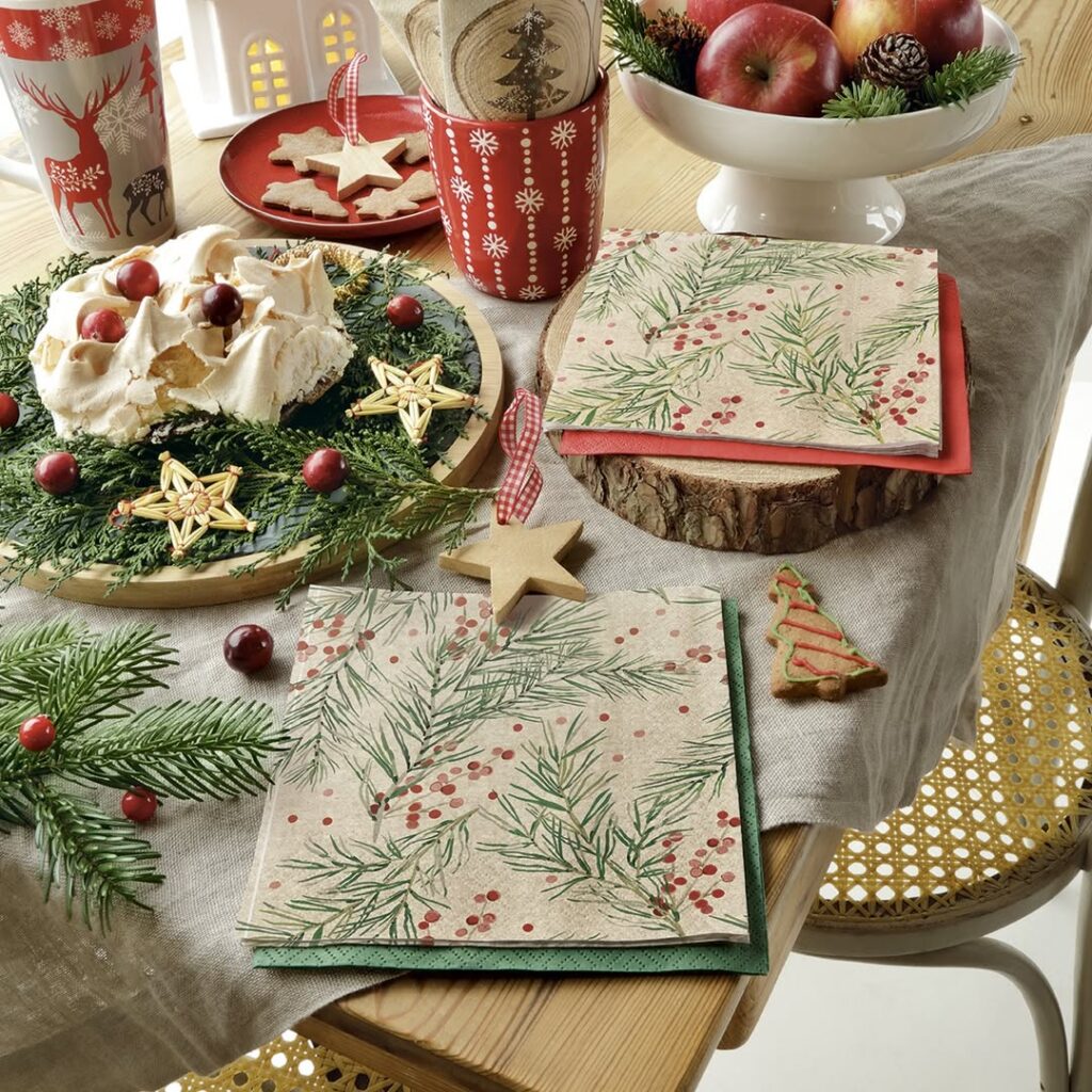 Mesa com enfeites natalinos e guardanapos com temas de Natal