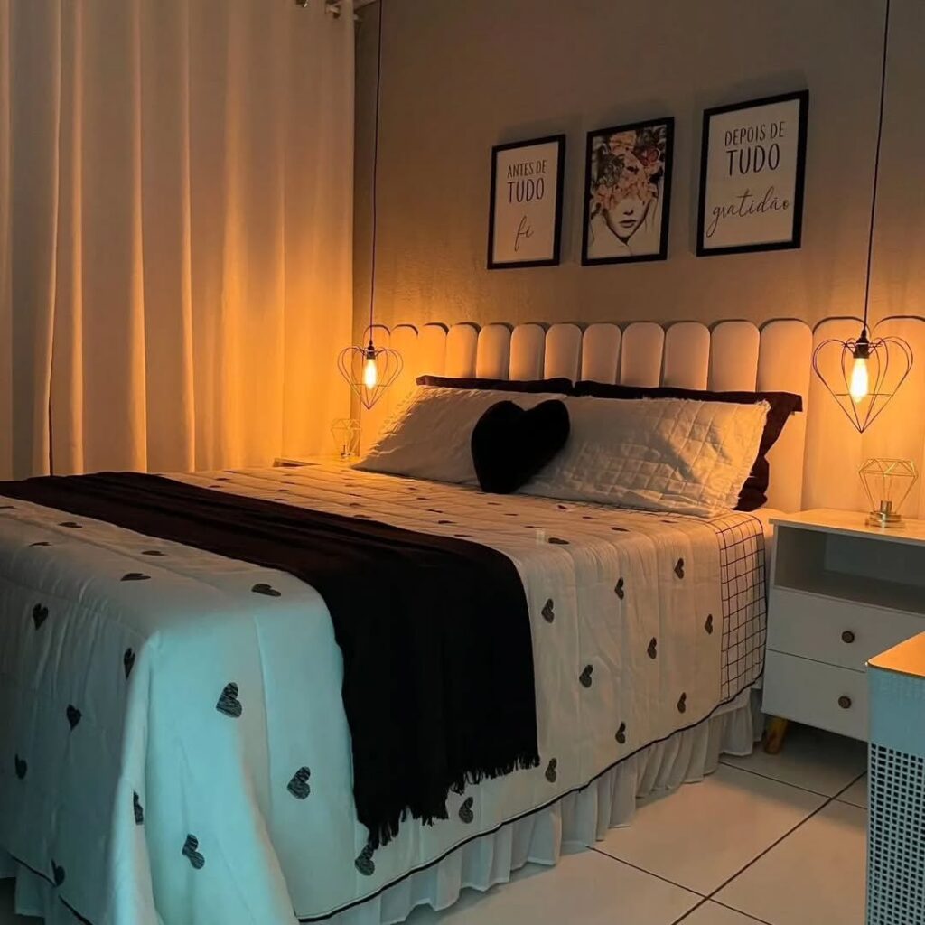 Quarto com cabeceira estofada modular, quadros acima e pendentes em formato de coração