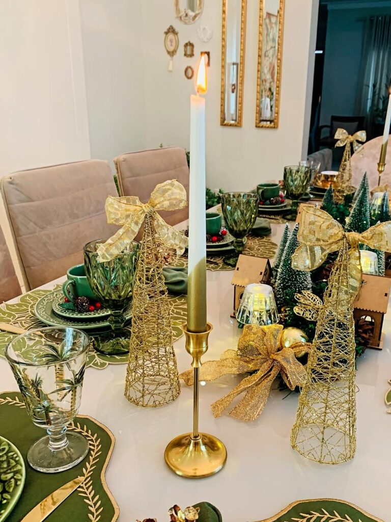 Mesa com castiçais e árvores aramadas douradas
