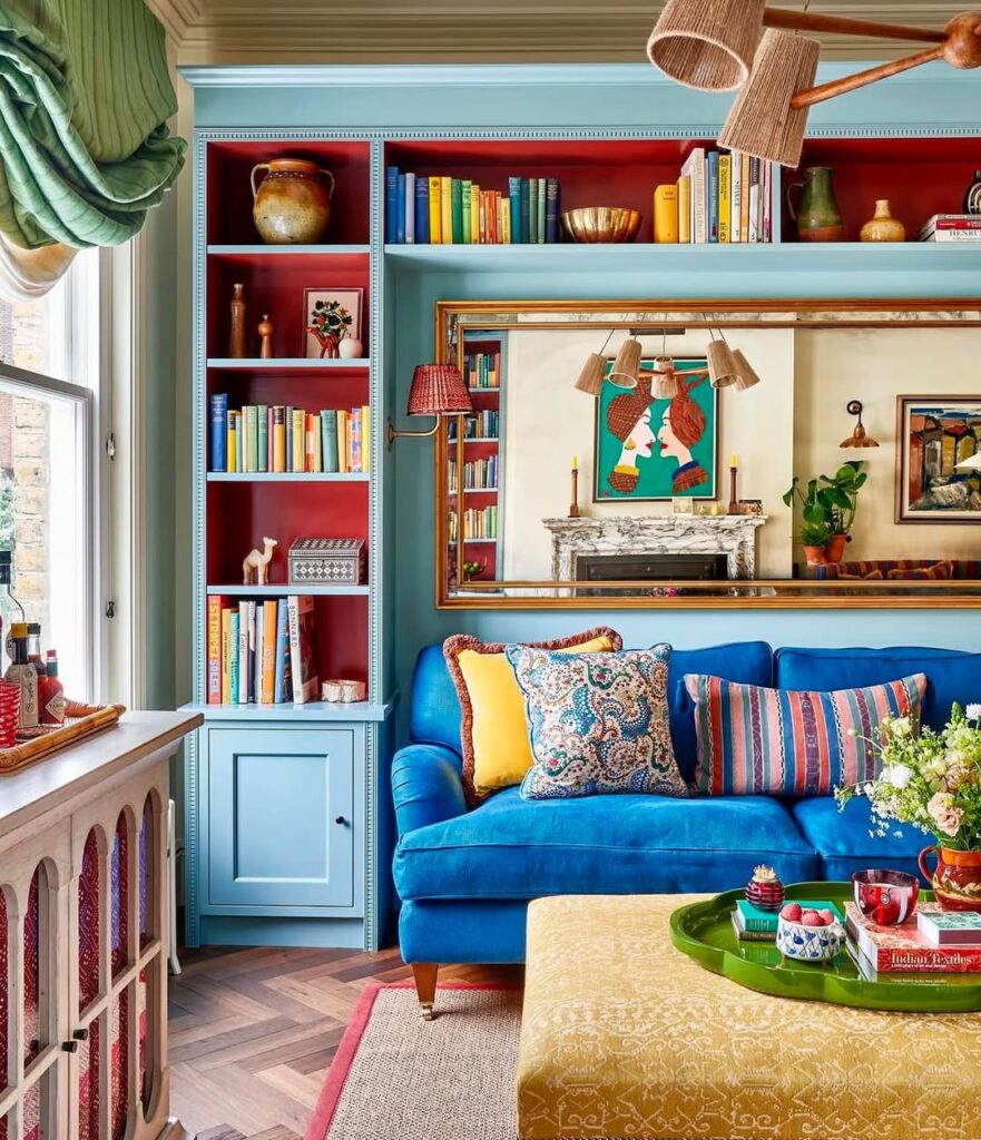Sala de estar com estante azul e fundo bordô, sofá azul com almofadas coloridas