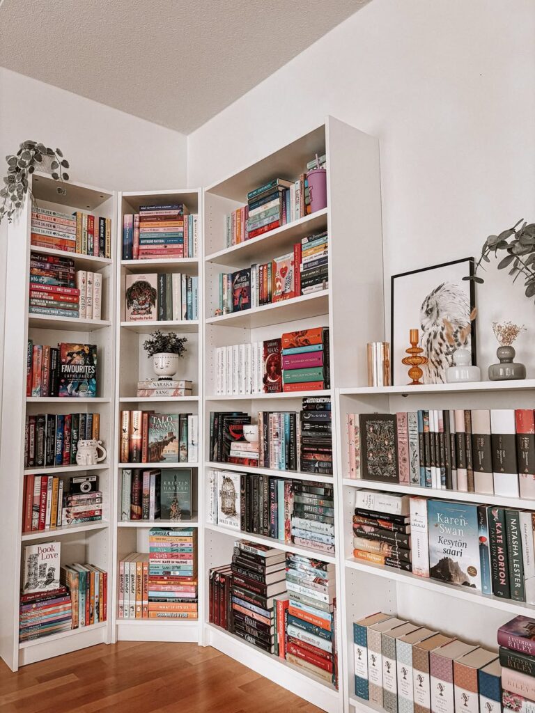 Estantes de livros brancas com quadros e objetos decorativos