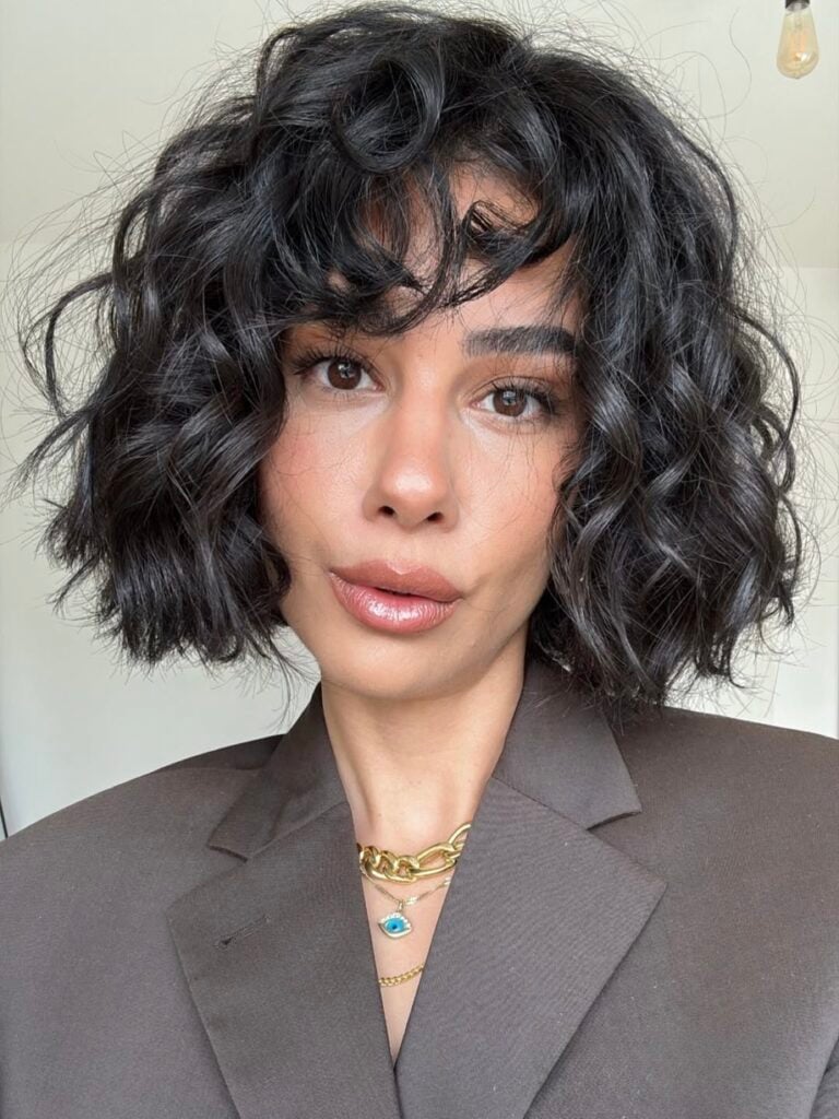 Mulher de pele clara, com cabelo cacheado em corte french bob