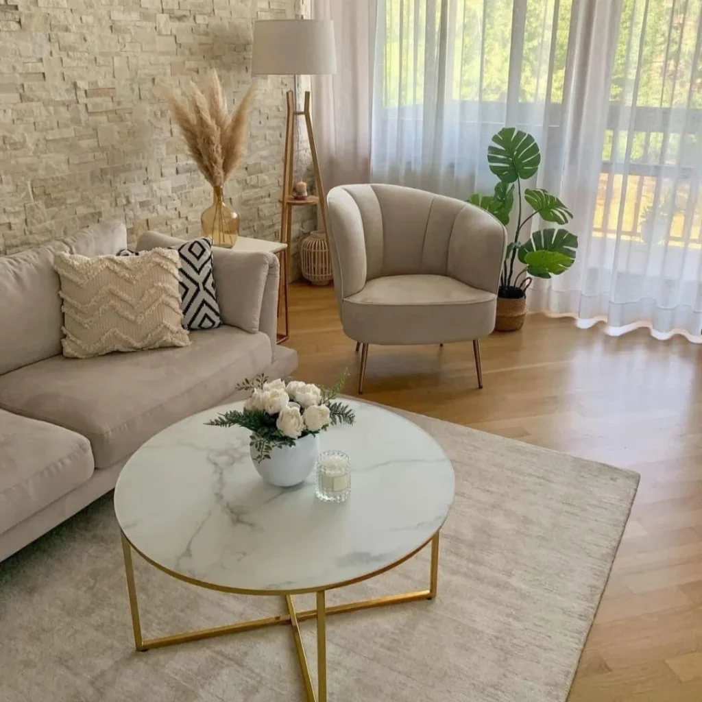Sala em tons neutros com sofá, poltrona, mesa de centro e luminária de piso