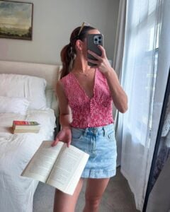 Mulher de pele clara, com blusa xadrez e saia jeans