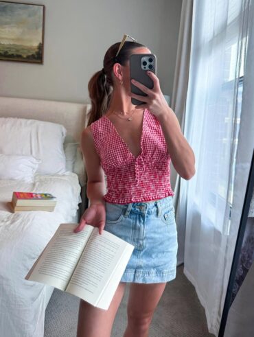 Mulher de pele clara, com blusa xadrez e saia jeans