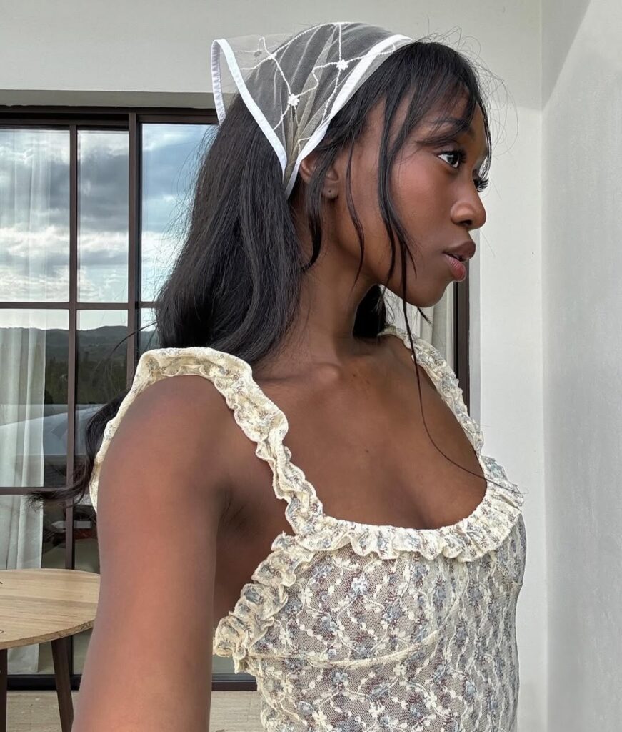 Mulher jovem usando lenço de renda e blusa de renda