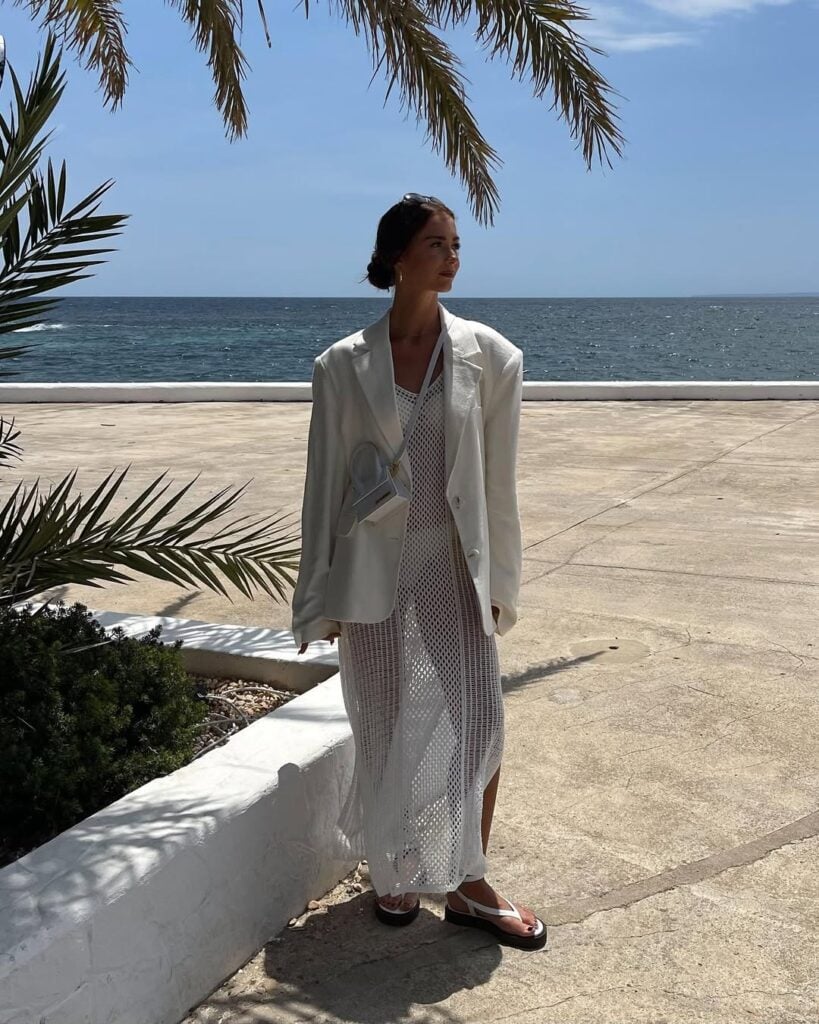 Mulher jovem com biquini branco, saida de praia, blazer e sandália