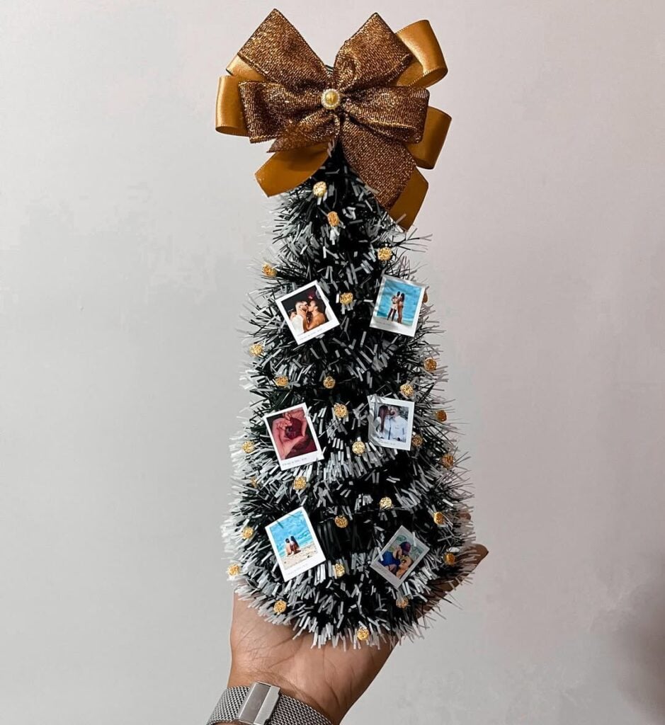 Mini árvore de Natal com pequenas fotos e laço dourado