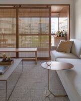 Sala de estar com sofá bege e painel grande de muxarabi