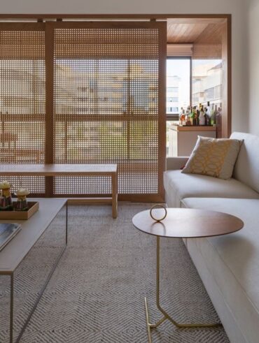 Sala de estar com sofá bege e painel grande de muxarabi