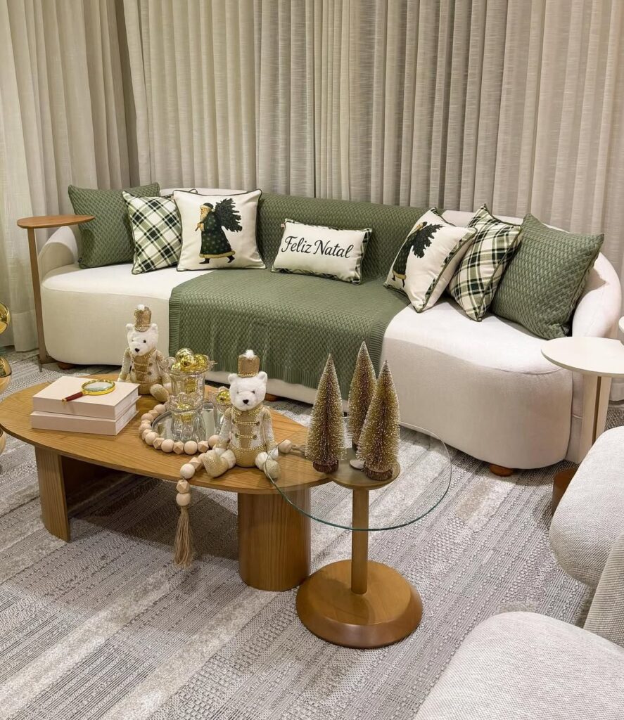 Sala de estar com sofá orgânico branco com manta e almofadas de Natal em verde e dourado