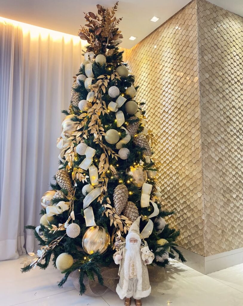 Árvore de Natal nas cores verde e dourado, com pinhas, laços, bolas e Papai Noel em cores claras