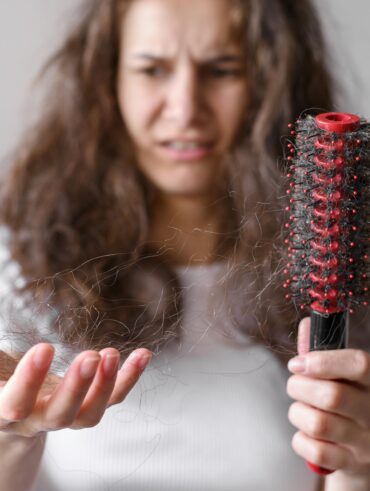 Mulher de pele clara, com cabelo nas mãos
