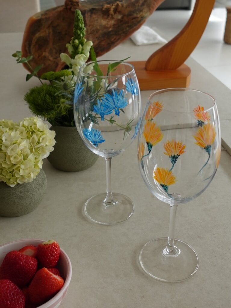 Taças transparentes com flores pintadas em azul e laranja