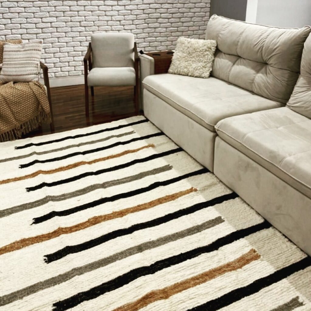 Sala em tons de cinza e marrom com tapete listrado