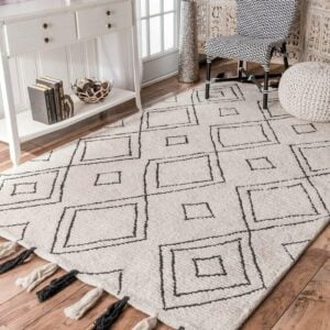 Ambiente com aparador branco, pufe de crochê, cadeira em branco e preto e tapete boho grande