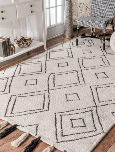 Ambiente com aparador branco, pufe de crochê, cadeira em branco e preto e tapete boho grande