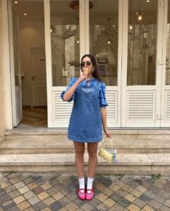 Mulher jovem de pele clara com vestido curto jeans