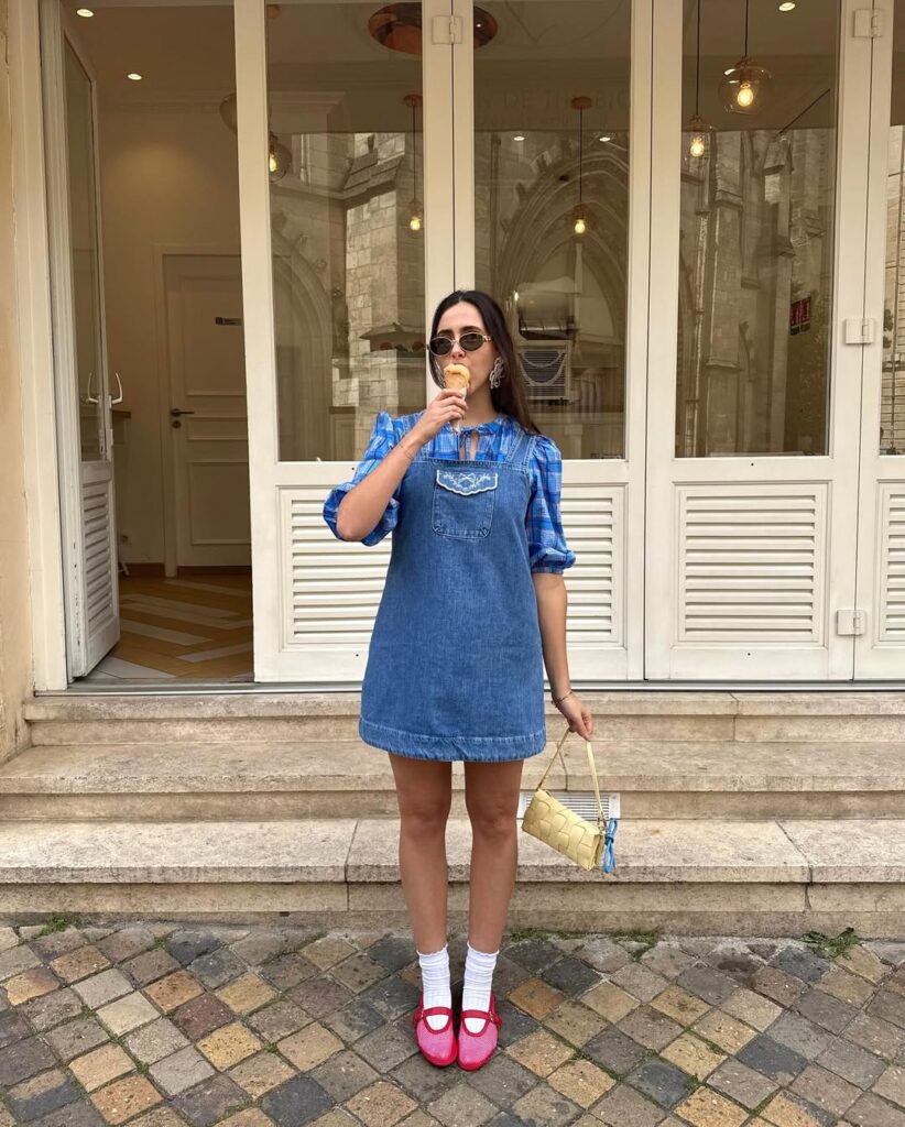 Mulher jovem de pele clara com vestido curto jeans